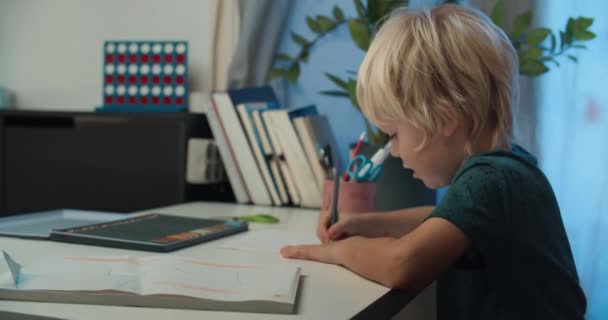 Cute child boy drawing with pencil sitting at the table on Christmas holidays — Video Stock