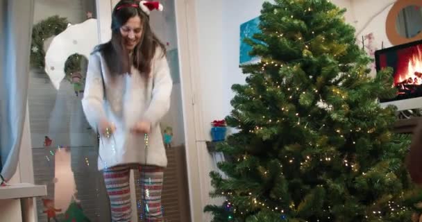 Happy young woman dancing with decoration garland lights preparing for Christmas — Stockvideo