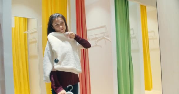 Junge attraktive Frau wählt beim Einkaufen neue Kleidung — Stockvideo