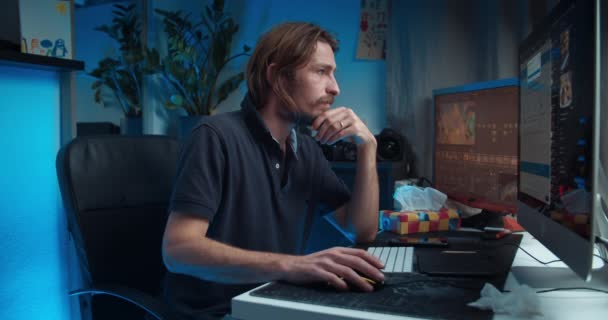Nemocný mladý muž na volné noze sedí u stolu před počítačem a kašle — Stock video