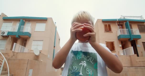 Söt pojke dricka ekologisk tomatjuice från glas utomhus — Stockvideo