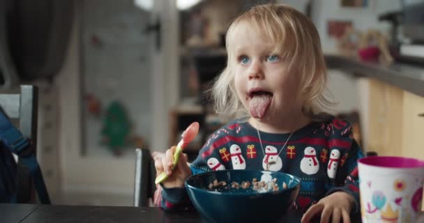 Roztomilé dítě dívka jí pohankovou kaši jako večeři na večer v jídelně — Stock video