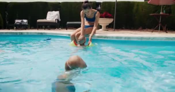 Семья на летнем отдыхе отдыхает на бассейне — стоковое видео