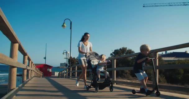 Familie wandelen op de promenade tijdens reizen op zomervakantie 's avonds — Stockvideo