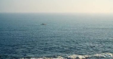 Ufukta balıkçıyla deniz burnu Katamaran kayığında tek başına balık tutarken