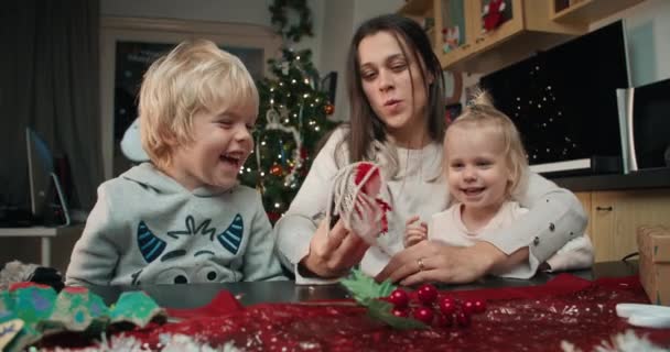 Famille joyeuse faire cadeau de Noël fait à la main et jouer ensemble — Video