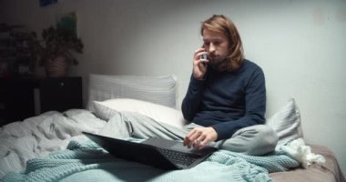 Freelance worker using laptop computer and receiving telephone call