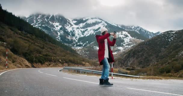 Mujer joven en el camino vacío de montaña hace selfie en el teléfono inteligente — Vídeo de stock