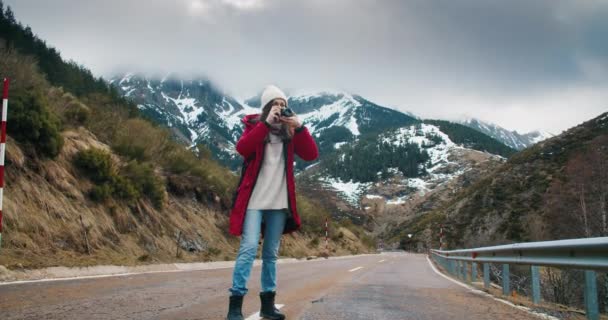 Viaggiatore e fotografo professionista cammina sulla strada di montagna vuota foto scattata — Video Stock