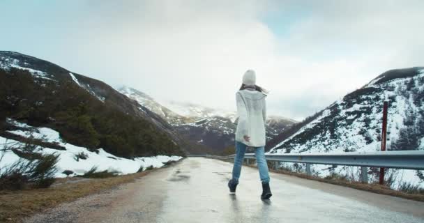Excited traveler young woman walk on empty mountain road — Video Stock