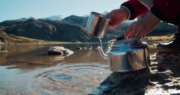 Woman in red jacket scoop water with cup and pouring to kettle — Vídeo de Stock