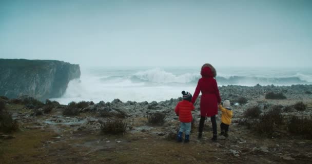 Familia vino a ver grandes olas de tormenta en el borde de la orilla del océano — Vídeo de stock