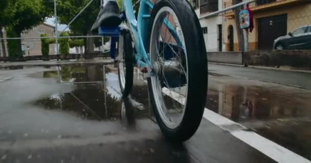 Мальчик ездит на велосипеде после дождя — стоковое видео