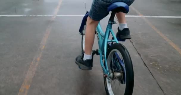 Ruční Kinematografické Záběry Dětského Chlapce Jezdit Kole Mokré Podlaze Deštivý — Stock video