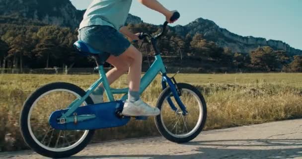 Неузнаваемый Счастливый Мальчик Едет Велосипеде Проселочной Дороге Видом Горы Закате — стоковое видео