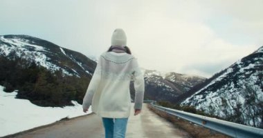 Heyecanlı kaygısız kadın beni takip ettiğini ve boş dağ yolunda yürüdüğünü gösteriyor. Çekici bayan gezgin tatillerde yürüyüşe çıkıyor ve gülümsüyor. Mutlu kız açık havada aktif ve sağlıklı bir hayat sürüyor..