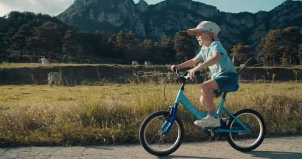 Zorgeloze Kinderfiets Lege Landweg Zomeravond Met Uitzicht Bergen Kind Geniet — Stockvideo