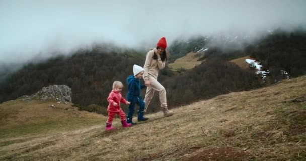 Genç Yetişkin Bir Kadın Bahar Yolculuğunda Çocuklarla Birlikte Dağa Tırmanır — Stok video