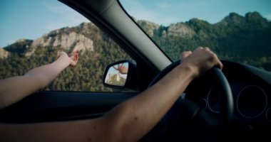 Genç bir kadın yaz yolculuğunda elini pencereden dışarı atarak araba kullanıyor. Kız elini arabanın camından dışarı uzatır ve temiz meltemin ya da rüzgarın tadını çıkarır. Yol gezisinde ilham veren kadın.