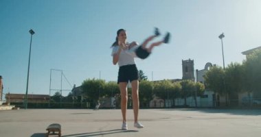 Mutlu neşeli aile yaz tatilinde birlikte vakit geçiriyor. Genç yetişkin bir kadın kızının etrafında dönüyor ve gülümsüyor. Çocuklar yazın anneleriyle eğleniyor. Spor sahasında neşeli kadınlar