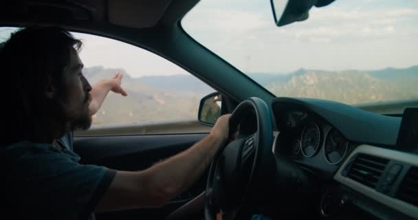 Hipster Młody Człowiek Prowadzi Samochód Górskiej Drodze Epickim Widokiem Zachodzie — Wideo stockowe