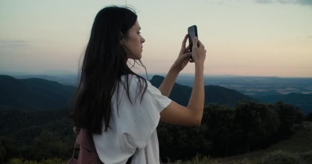 Piękna Młoda Kobieta Robi Zdjęcie Lub Wideo Pomocą Smartfona Stojącego — Wideo stockowe