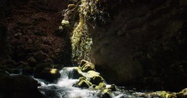 Sunbeam breaks through the mountains on fast mountain stream. Pure river among the rocks. Travel on the mountains with waterfall river.