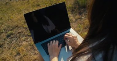 Dışarıda dizüstü bilgisayar kullanarak güzel ve bağımsız bir kadının sırtından vurulmuş. Kadın programcı defter klavyesine kod yazıyor. İnsanlar teknolojiyi seyahatlerde kullanıyorlar