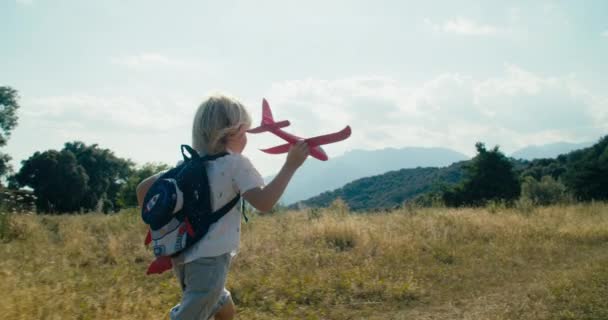Dreaming Children Backpack Running Mountain Meadow Holding Toy Model Plane — Stok video