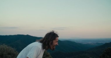 Cheerful man on summer vacation mountain travel smile and taking picture of beautiful landscape using mobile phone. Male traveler using technology on trip to save memories about journey adventure