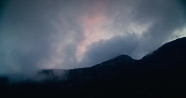 Rainy clouds movement shot in timelapse on travel. Dramatic beautiful cloudscape on mountain silhouette. Concept of weather on hiking trip. 