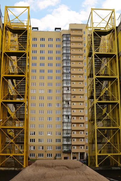Желтые лестницы против небоскреба — стоковое фото