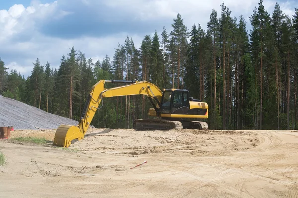 Yellow excavator on the background of heaps of sand — Stock Photo, Image