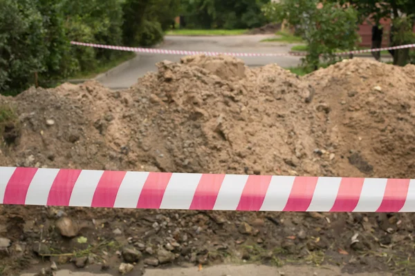 Fragment der Reparatur von Straßen, abgetrenntes Schutzband — Stockfoto