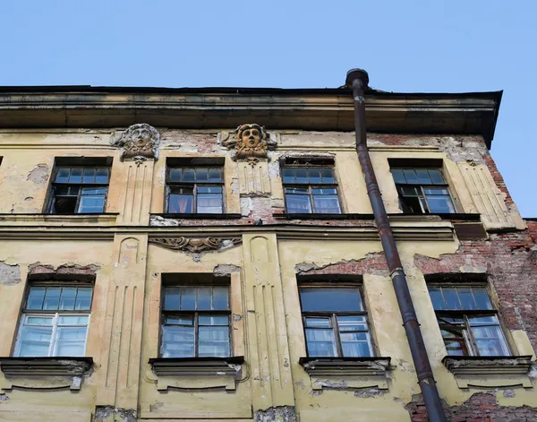 Detalhe da fachada da antiga casa com duas estátuas — Fotografia de Stock