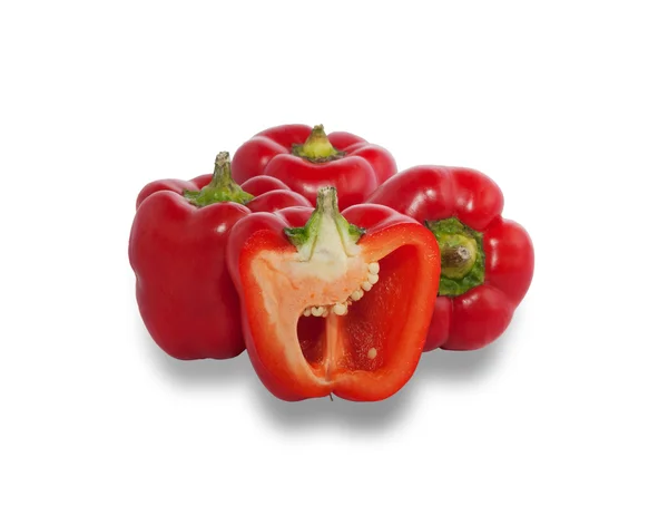 Several ripe red peppers, one of which is cut in half — Stock Photo, Image