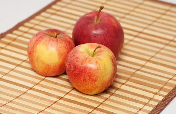 Fyra moget rött äpple på wicker servett — Stockfoto