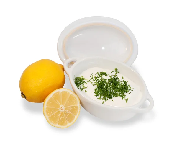 Weiße Sauce in einer weißen Porzellanschale, Zitrone und gehacktem Dill, i — Stockfoto