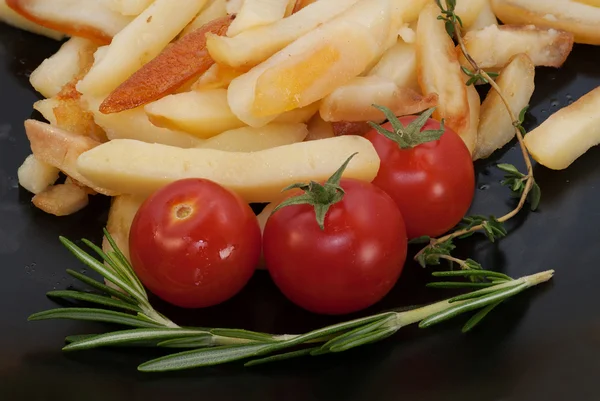 Cherry tomatoes, fried potatoes and branch of rosemary — Stock Photo, Image