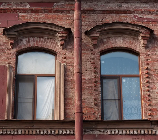 Two windows and drainpipe, on red brick wall — Stock Photo, Image