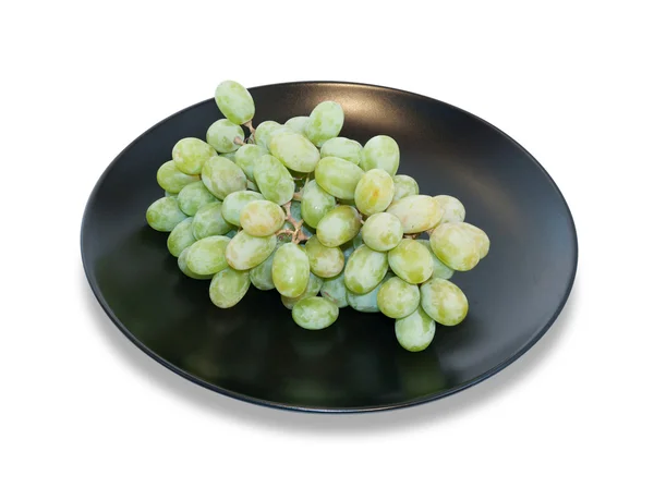Zielony winogron na czarny danie na białym tle — Zdjęcie stockowe