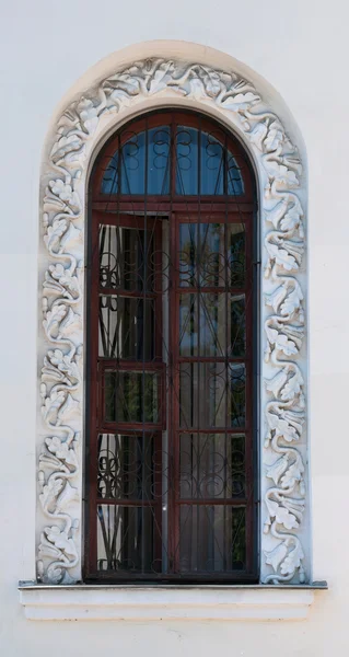 Window of old house with decoration in form of oak leaves — Stock Photo, Image