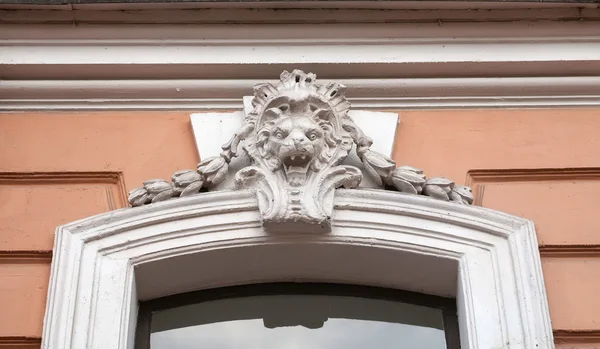 Fragmento de um edifício antigo com cabeça de leão de baixo relevo — Fotografia de Stock