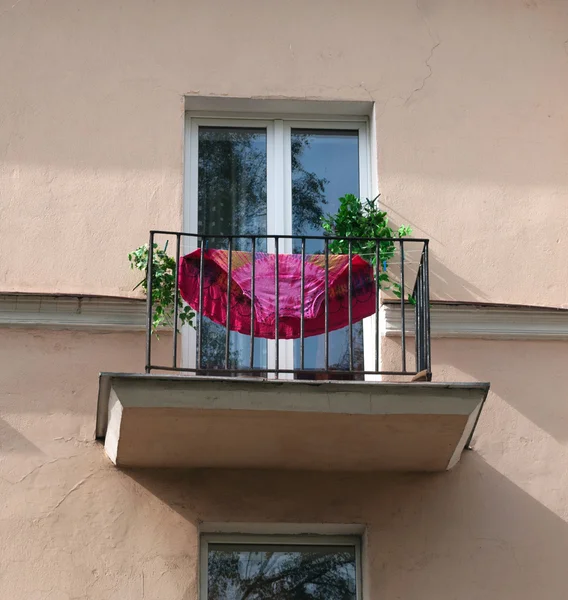 Balcón casa vieja con vestido rojo —  Fotos de Stock