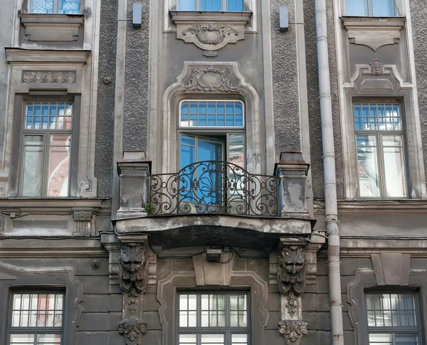 Фасадный дом с балконом и скульптурными украшениями — стоковое фото