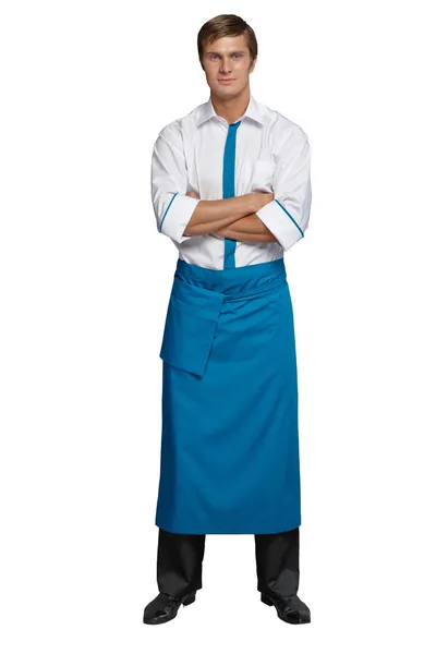 Young man in the form of a waiter or chef, white shirt, blue apron, black pants — Stock Photo, Image