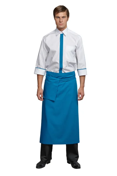 Young man in the form of a waiter or chef, white shirt, blue apron, black pants — Stock Photo, Image