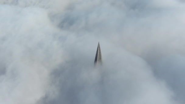 Россия, Санкт-Петербург, 14 октября 2021 года: Вершина самого высокого небоскреба в Европе над облаками, здание нефтяной компании "Газпром", шпиль металлической и стеклянной конструкции — стоковое видео
