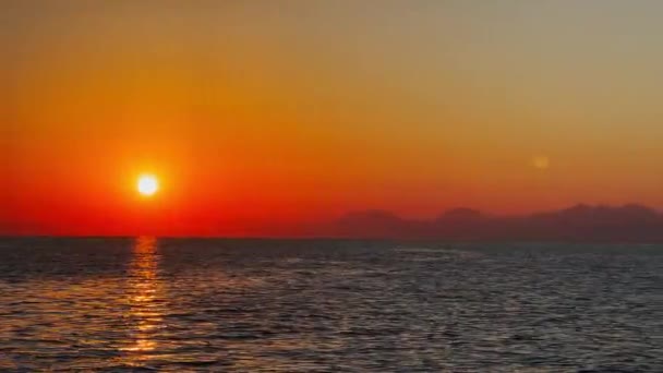 Hareket halindeki bir yattan, dağların arka planında gün batımını hayal edin. — Stok video