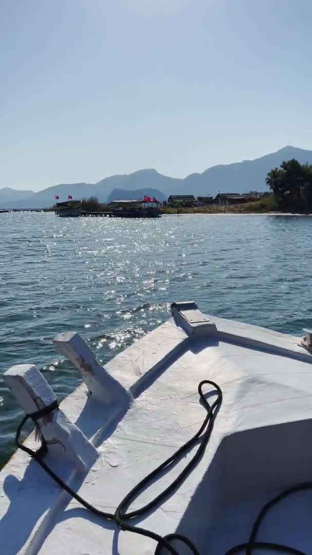Imagens verticais de barco em movimento, a pitoresca baía de Dalyan, na Turquia, perto de uma das muitas ilhas perto de Fethiye, barcos de passageiros, montanhas no fundo — Vídeo de Stock